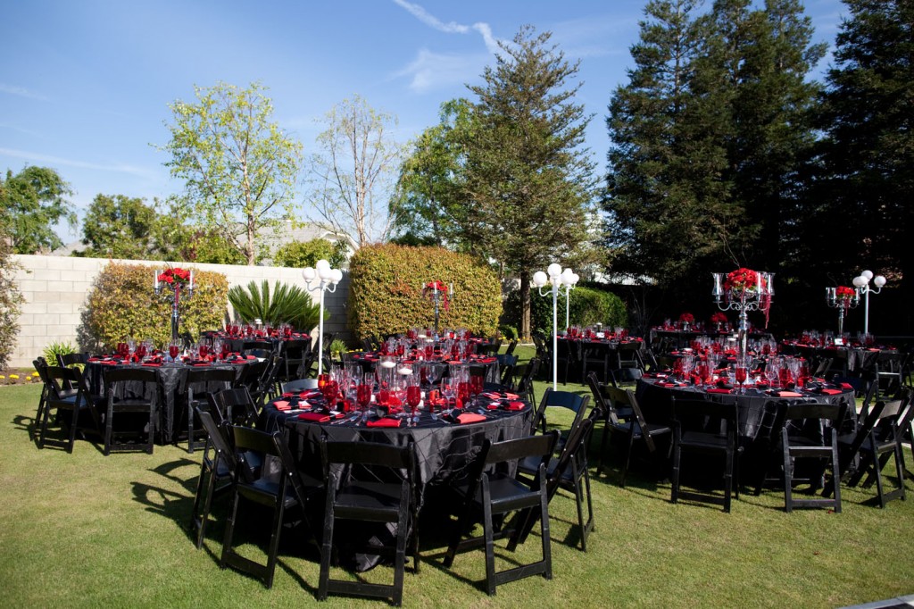 black reception tables with red flowers